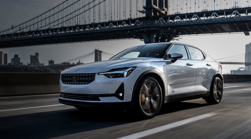 Photo of the Polestar 2 driving on a road near a bridge